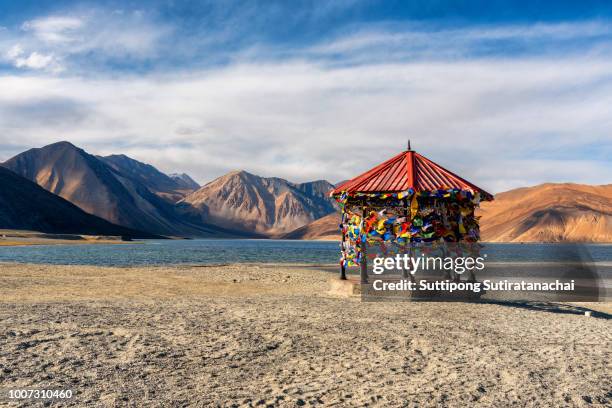 red pavilion in mountains and pangong tso (lake). it is huge and highest lake in ladakh and blue sky in background, it extends from india to tibet. leh, ladakh, jammu and kashmir, india - tibet stock photos et images de collection