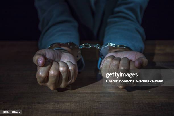 arrested business man handcuffed hands. close-up. - häftling stock-fotos und bilder