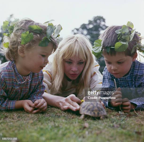 French born American actress Leslie Caron pictured with her two children Jennifer Caron Hall and Christopher Hall as they play with a pet tortoise in...