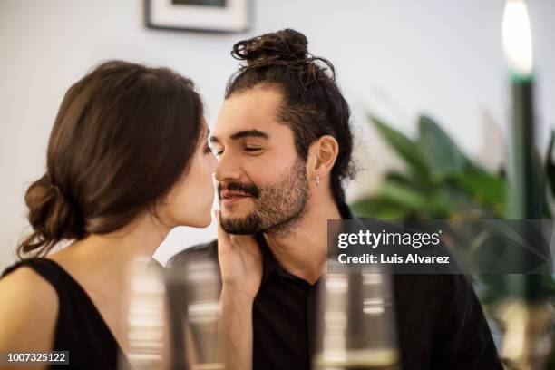 couple kissing during dinner party at home - brown hair drink wine stock-fotos und bilder