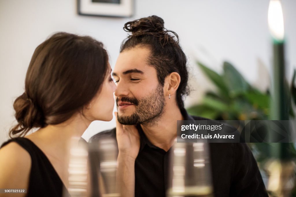 Couple kissing during dinner party at home