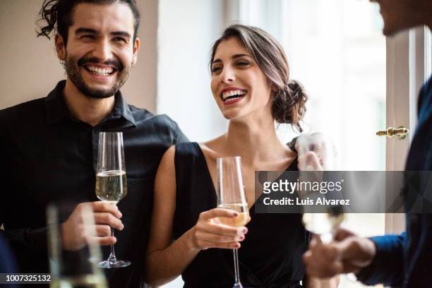 happy couple champagne flutes during dinner party - hombre vestido de mujer fotografías e imágenes de stock