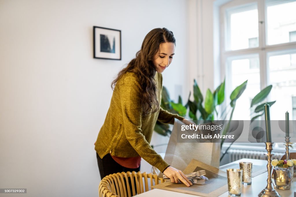 Woman arranging dining table for dinner party