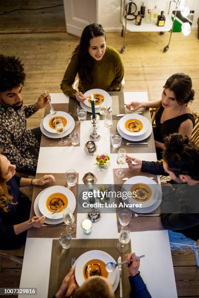 multi-ethnic friends having squash soup at dinning table - candle overhead stock pictures, royalty-free photos & images