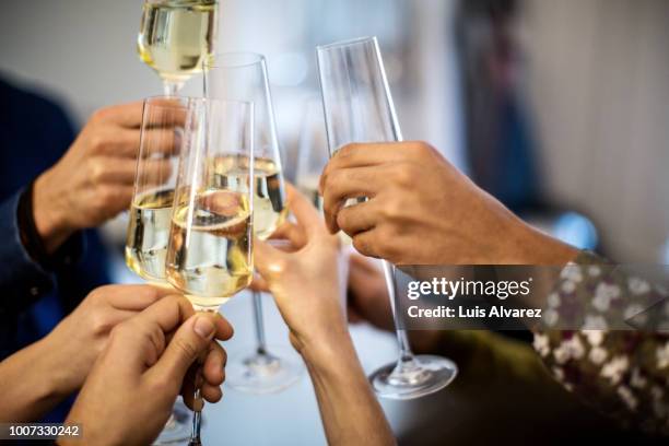 hands toasting champagne flutes during dinner party - brindis fotografías e imágenes de stock