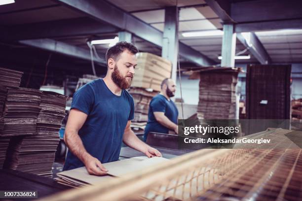 pappenfabrik arbeiter faltschachteln und den transport von paletten für den versand - überstunden machen stock-fotos und bilder
