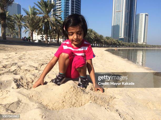 young girl (2-3 years) playing in beach sand - sandcastle stock pictures, royalty-free photos & images