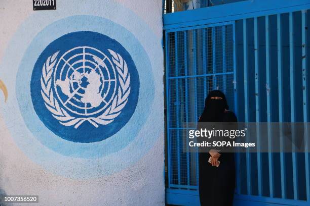 Woman stands in front of UNRWA headquarters during the protest. Palestinian employees of UNRWA take part in a demonstration against job cuts...
