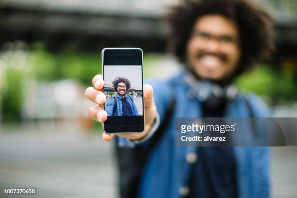 hipster zeigt seine selfie - photo call stock-fotos und bilder