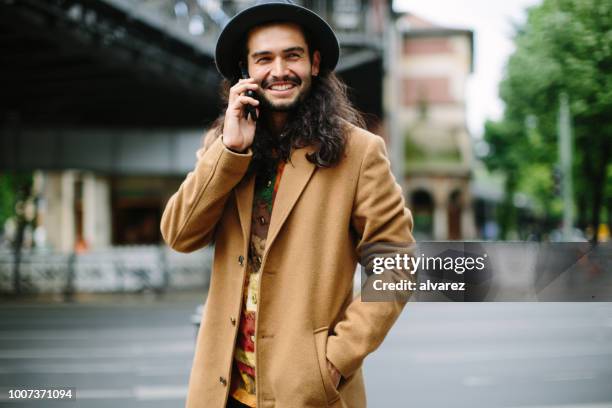 urban man talking on phone - long coat stock pictures, royalty-free photos & images