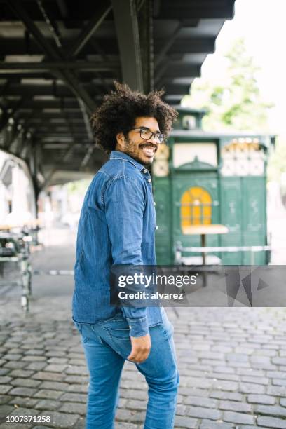 smiling african man walking down the street - portrait looking down stock pictures, royalty-free photos & images