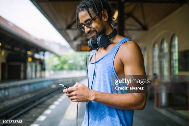 man i väst med smart telefon på railroad station - dreadlocks bildbanksfoton och bilder