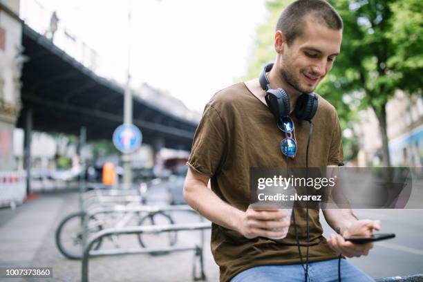 hombre joven relajándose al aire libre en la ciudad - berlin cafe fotografías e imágenes de stock