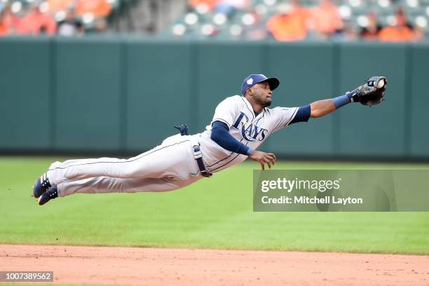 Adeiny Hechavarria of the Tampa Bay Rays dives after a hit by Mark Trumbo of the Baltimore Orioles in the eight inning during a baseball game at...