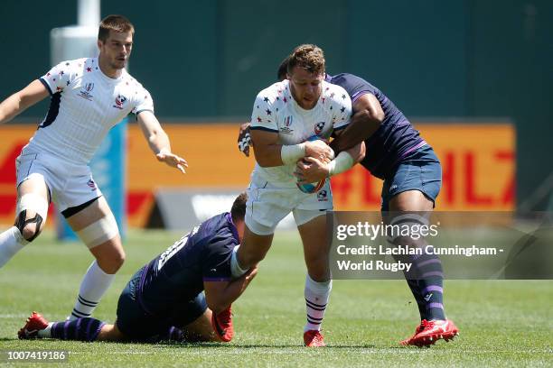 Stephen Tomasin of the United States is tackled by Gavin Lowe and Joe Nayacavou of Scotland during day three of the Rugby World Cup Sevens at AT&T...