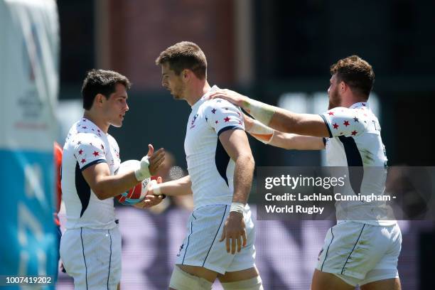 Bret Thompson of the United States celebrates with teammates Madison Hughes and Stephen Tomasin after scoring a try against Scotland during day three...