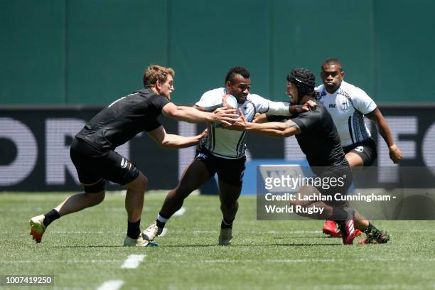 Jerry Tuwai of Fiji is tackled by Trael Joass and Scott Curry of New Zealand during their semi final match on day three of the Rugby World Cup Sevens...