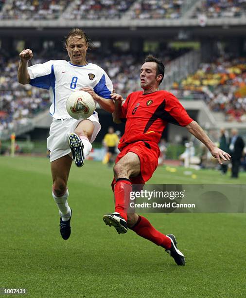 Bart Goor of Belgium challenges Valery Karpin of Russia in the first half during the Belgium v Russia, Group H, World Cup Group Stage match played at...