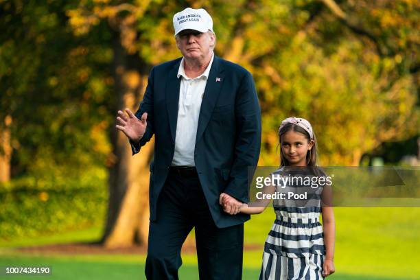 President Donald Trump and his granddaughter Arabella Rose Kushner walk across the South Lawn as they return from a weekend stay in Bedminster, New...