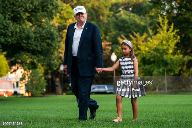 President Donald Trump and his granddaughter Arabella Rose Kushner walk across the South Lawn as they return from a weekend stay in Bedminster, New...