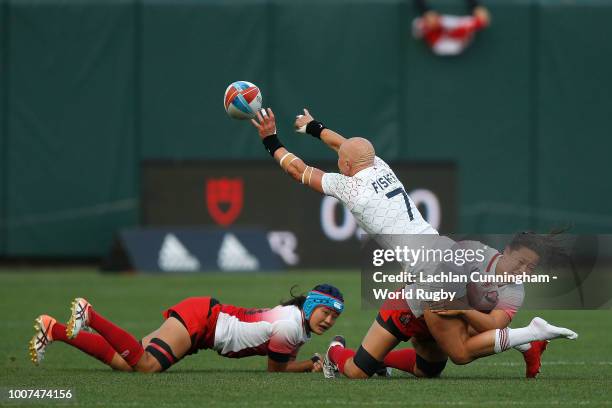 Heather Fisher of England is tackled by Iroha Nagata and Yukari Tateyama of Japan during day two of the Rugby World Cup Sevens at AT&T Park on July...