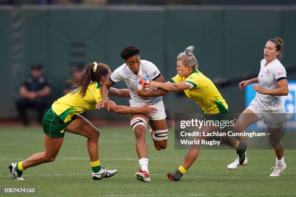 Kristen Thomas of the United States is tackled by Evania Pelite and Emma Tonegato of Australia during day two of the Rugby World Cup Sevens at AT&T...