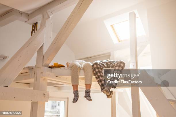paar am morgen mit einem frühstück im bett liegend - dachgeschoß stock-fotos und bilder