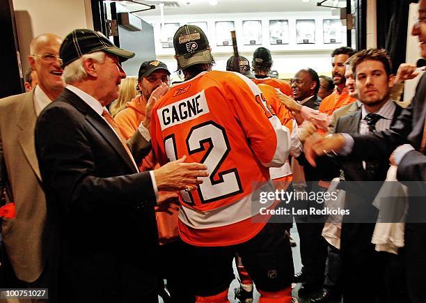 Simon Gagne of the Philadelphia Flyers walks into the locker room past Flyers Chairman Ed Snider after defeating the Montreal Canadiens 4-2 in Game...