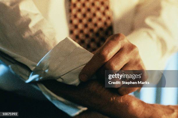 businessman rolling up sleeve - sleeve roll stock pictures, royalty-free photos & images