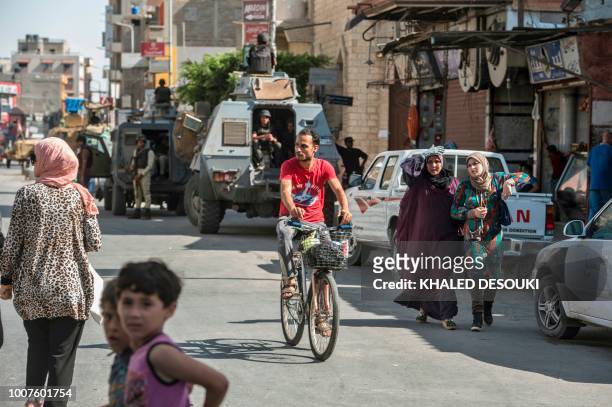 Picture taken on July 26, 2018 shows Egyptian policemen stand guarding a street in the North Sinai provincial capital of El-Arish. - With fruit and...