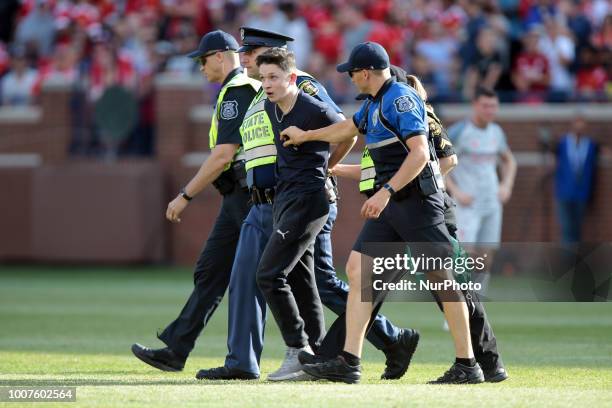 Fan is removed by police officers after rushing the field during an International Champions Cup match between Manchester United and Liverpool at...