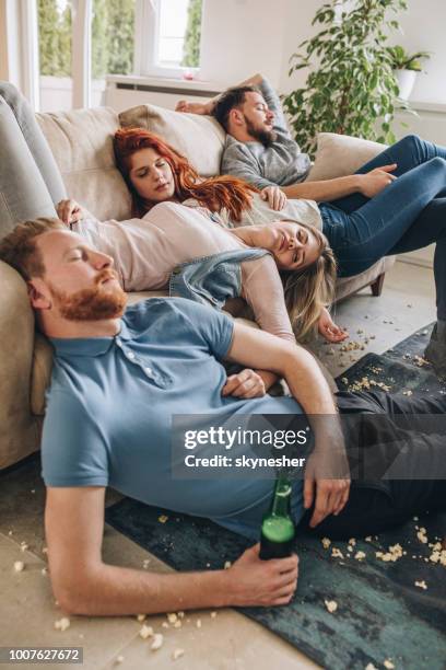 group of wasted friends sleeping after the party in the living room. - messy house after party stock pictures, royalty-free photos & images