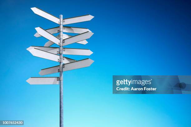 a 3d pole with blank street signs pointing all directions - richtung stock-fotos und bilder