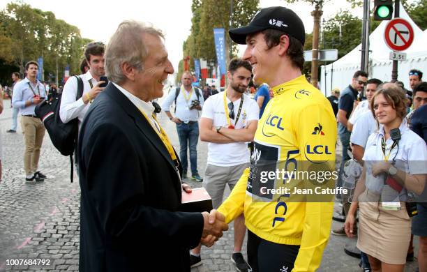 Of Tissot Francois Thiebaud gives a watch to yellow jersey Geraint Thomas of Great Britain and Team Sky following stage 21 of Le Tour de France 2018...