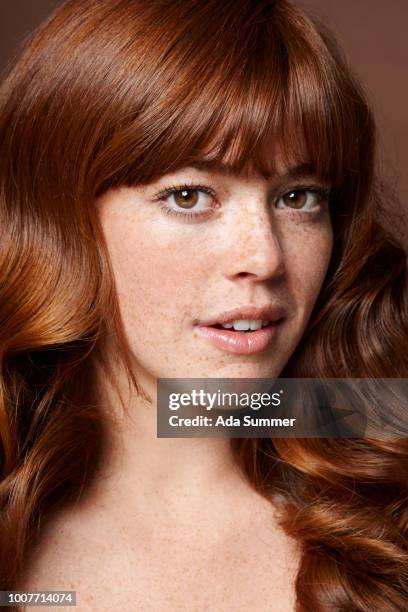 smiling woman with windblown red long hair - cheveux ondulés photos et images de collection
