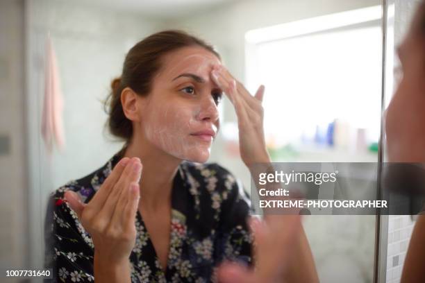 mujer en el baño - crema facial fotografías e imágenes de stock