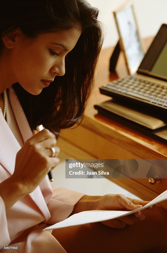 BUSINESSWOMAN WORKING ON DESK WITH LAPTOP