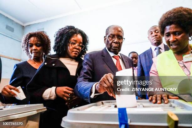 Former Zimbabwean president Robert Mugabe his daughter Bona and wife Grace cast their votes at a polling station at a primary school in the Highfield...