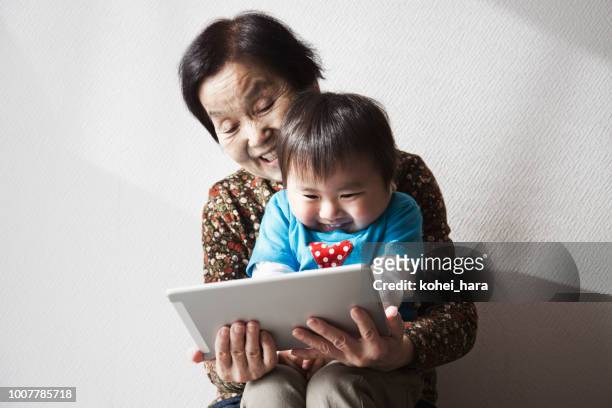 Grand mother and grand son using a digital tablet together