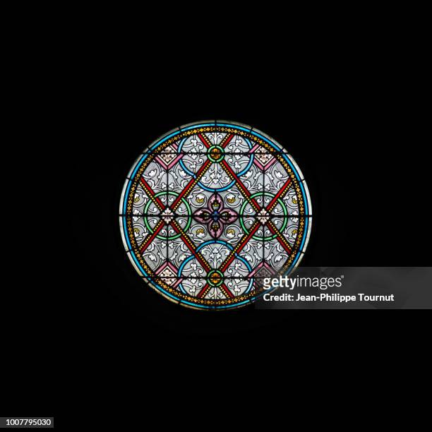 circular stained glass window of the church of carolles, normandy, france - carolles stock-fotos und bilder