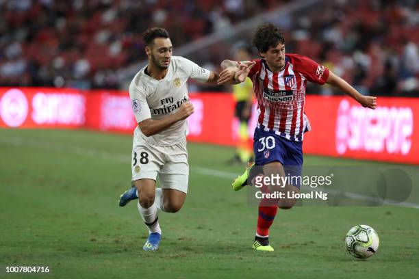 Azzedine Toufiqui of Paris Saint Germain and Roberto Olabe of Atletico Madrid chase after the ball during the International Champions Cup match...