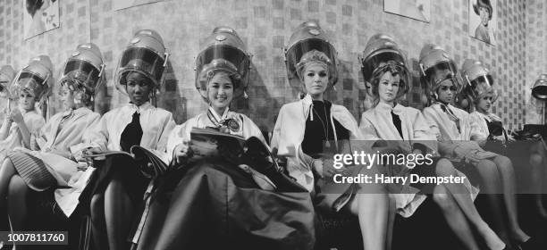 Contestants for the upcoming Miss World beauty pageant pictured together seated under hairdryers at a hairdressing salon in London on 12th November...