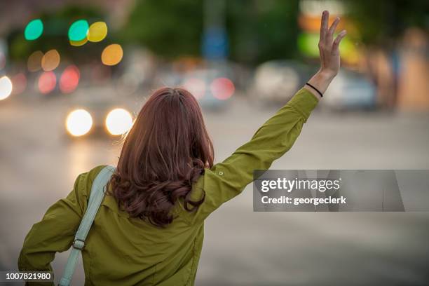 catturare l'attenzione di un taxi di passaggio - hail foto e immagini stock