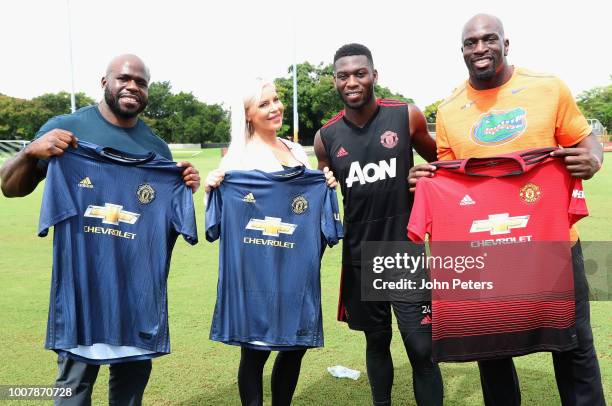 Timothy Fosu-Mensah of Manchester United poses with WWE wrestlers Apollo Crews, Dana Brooke and Titus O'Neil after a training session as part of...