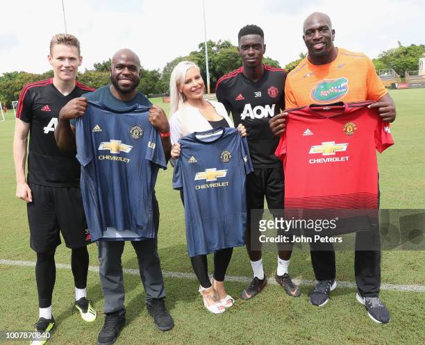Scott McTominay and Axel Tuanzebe of Manchester United pose with WWE wrestlers Apollo Crews, Dana Brooke and Titus O'Neil after a training session as...