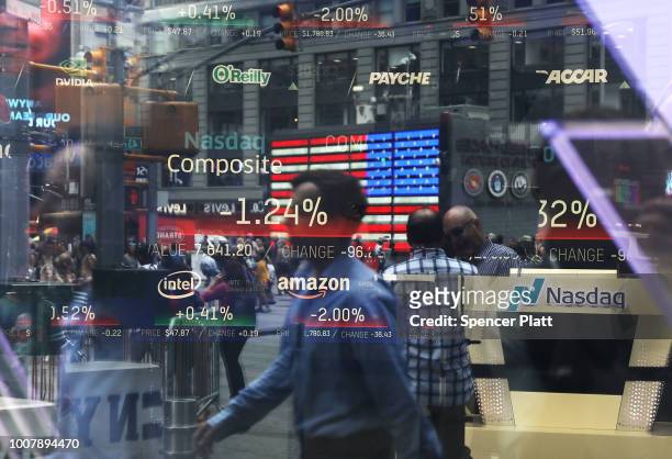 People are reflected in the window of the Nasdaq MarketSite in Times Square on July 30, 2018 in New York City. As technology stocks continued their...