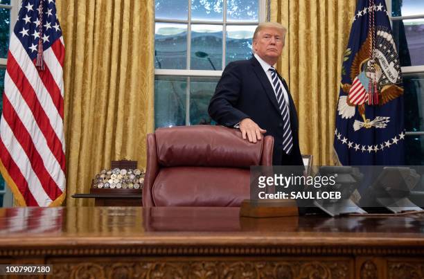 President Donald Trump stands behind the Resolute Desk after Robert Wilkie was sworn-in as Secretary of Veterans Affairs in the Oval Office of the...