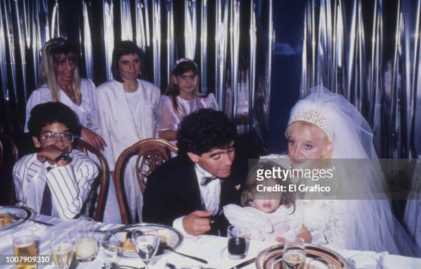 Diego Maradona and Claudia Villafañe pose with her daughter Dalma during their wedding at Luna Park Stadium on November 07, 1989 in Buenos Aires,...