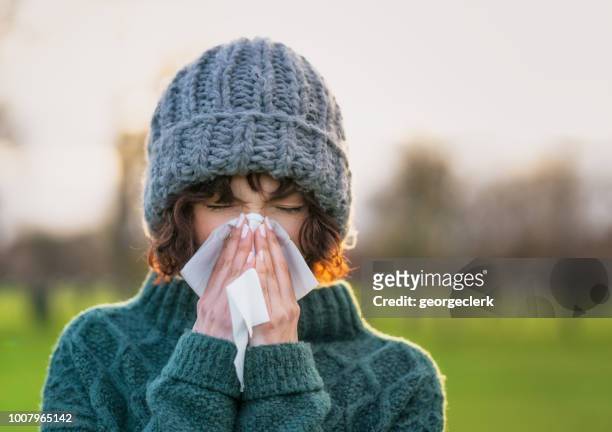 coping with a winter cold - blowing nose stock pictures, royalty-free photos & images