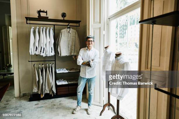 Portrait of smiling man standing in mens boutique while shopping for shirts